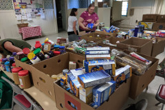 FCCMP staff sorting and creating grocery bags of food